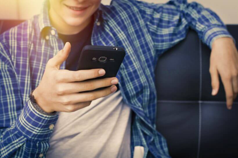 Teenager holding smartphone.