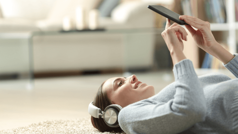 žena relaxuje díky nástrojům pro přehrávání hudby nebo videí a pro sledování televize